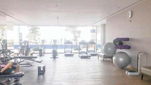 A gym with treadmills, stationary bikes, and exercise balls. - Studio (No Kitchen) With City Light View Benson Supermall Mansion Apartment (Surabaya)