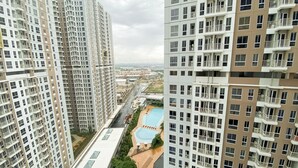 A high-rise residential building with multiple balconies, a swimming pool, and a view of the surrounding area. - Best Deal Studio At 23Rd Floor Tokyo Riverside Pik 2 Apartment (Teluknaga)