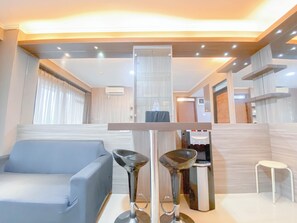 Een moderne woonkamer met een bank, een koffieapparaat en een bijzettafeltje.