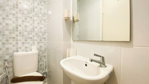 Un bagno con il water, un lavandino e uno specchio.