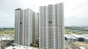 Due edifici residenziali con diversi balconi, un'area di parcheggio e vista sul paesaggio circostante.