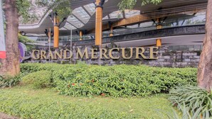 A building with a sign reading "GRAND MERCURE" and a modern architectural design with glass and metal elements. - Cozy Studio Apartment At Grand Mercure Yogyakarta (Yogyakarta)
