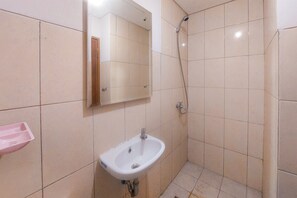 Bathroom features a pedestal sink, showerhead, and wall-mounted soap dish.