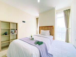 Cozy retreat with a large bed, shelf, and window with curtains.