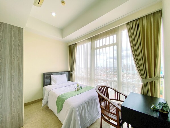 Relax in a stylish room with a large bed, desk, and city view.