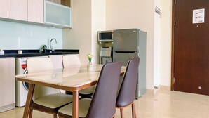 Cocina moderna con mesa, sillas y refrigerador.