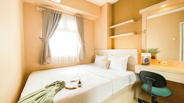 Comfortable room with a neatly made bed, bedside table, and chair, featuring a large window and a mirror.