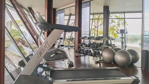 A gym with a treadmill, dumbbells, and exercise balls. - Cozy And Warm Studio Room At Uttara The Icon Apartment (Depok)