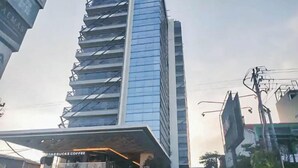 A modern building with a Starbucks Coffee shop at its base. - Cozy And Warm Studio Room At Uttara The Icon Apartment (Depok)