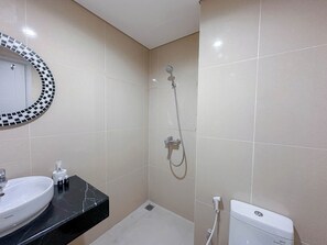 Un baño con lavamanos, espejo, ducha e inodoro.