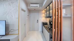 Una cocina moderna con horno empotrado, microondas y pileta. Se ve una puerta blanca que da a otra habitación.