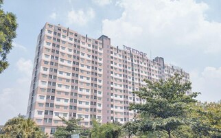 Un hotel de varios pisos con fachada uniforme, muchas ventanas y un cartel llamativo en la parte superior.
