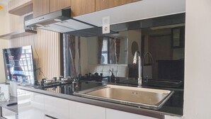 Une cuisine moderne dotée d’appareils électroménagers en acier inoxydable, d’un grand évier et d’armoires en bois.