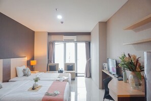 Relax in this stylish room with two single beds, a desk, and a seating area, offering a view of the outside.