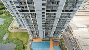 A high-rise building with multiple balconies, a swimming pool, and a basketball court. - Homey And Comfortable Studio Apartment At Daan Mogot City (Jakarta)