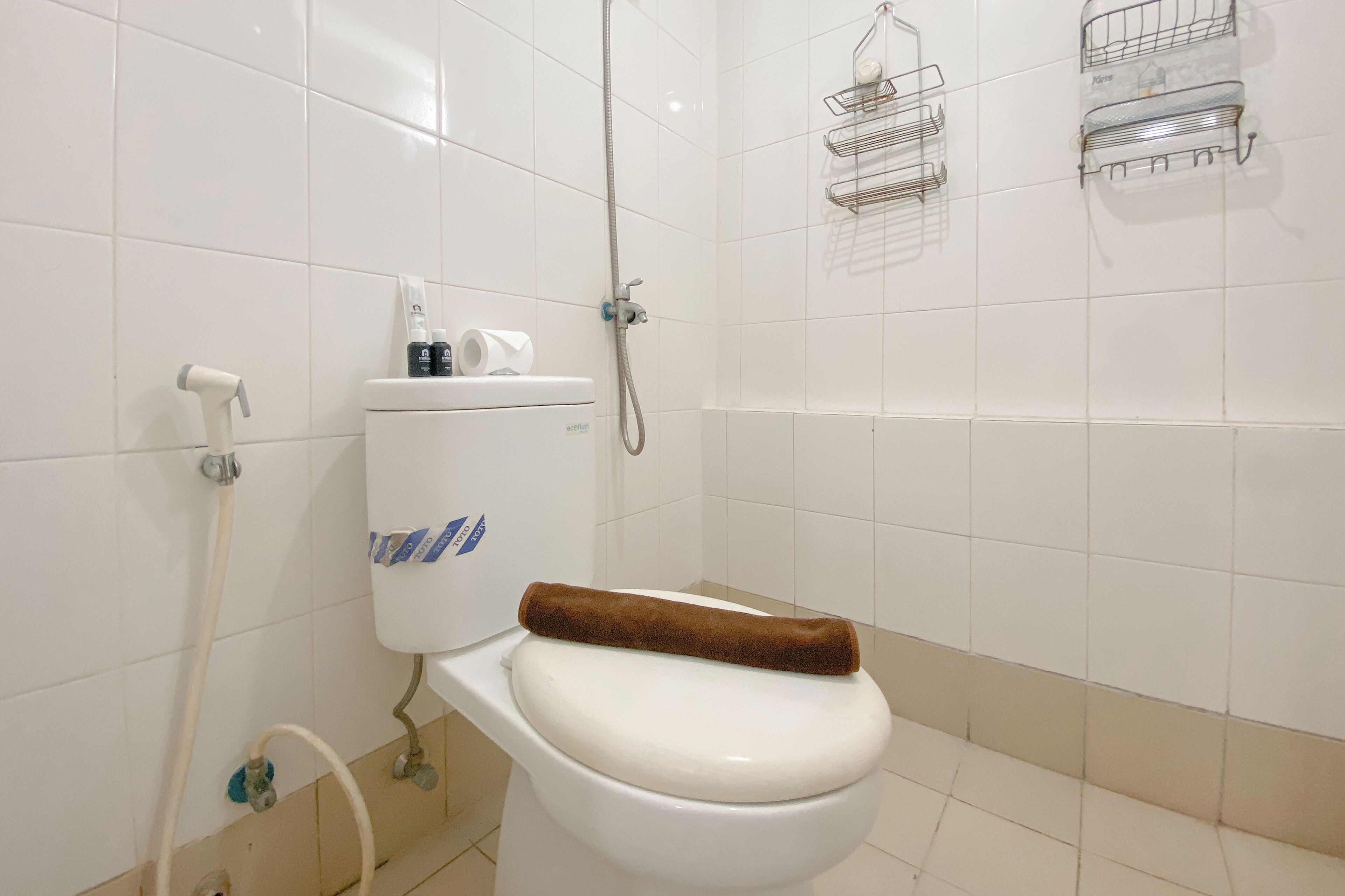 A bathroom with a toilet, a shower, and a towel rack.