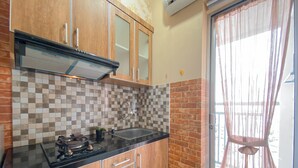 A kitchen with wooden cabinets, a tiled backsplash, a gas stove, and a sink.