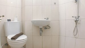 Une salle de bain avec des toilettes, un lavabo et une douche.