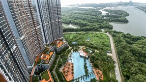 A high-rise building with a rooftop garden and a swimming pool. - Brand New And Homey Studio At Gold Coast Apartment Pik (Jakarta)