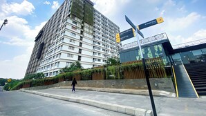 A modern building with a sign indicating directions to various locations. - Good Choice and Comfy Studio Apartment at LRT City Jatibening (Bekasi)