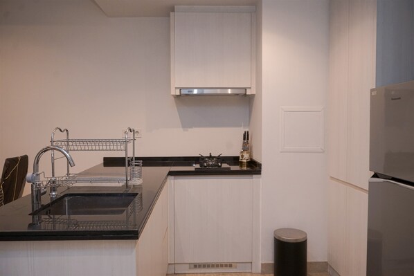 A modern kitchen with a stainless steel sink, a gas stove, and a built-in oven.