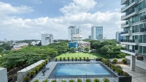 A rooftop pool with a view of surrounding buildings and greenery.