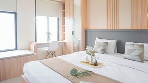 Une chambre d’hôtel moderne avec un grand lit, un bureau et une fenêtre.