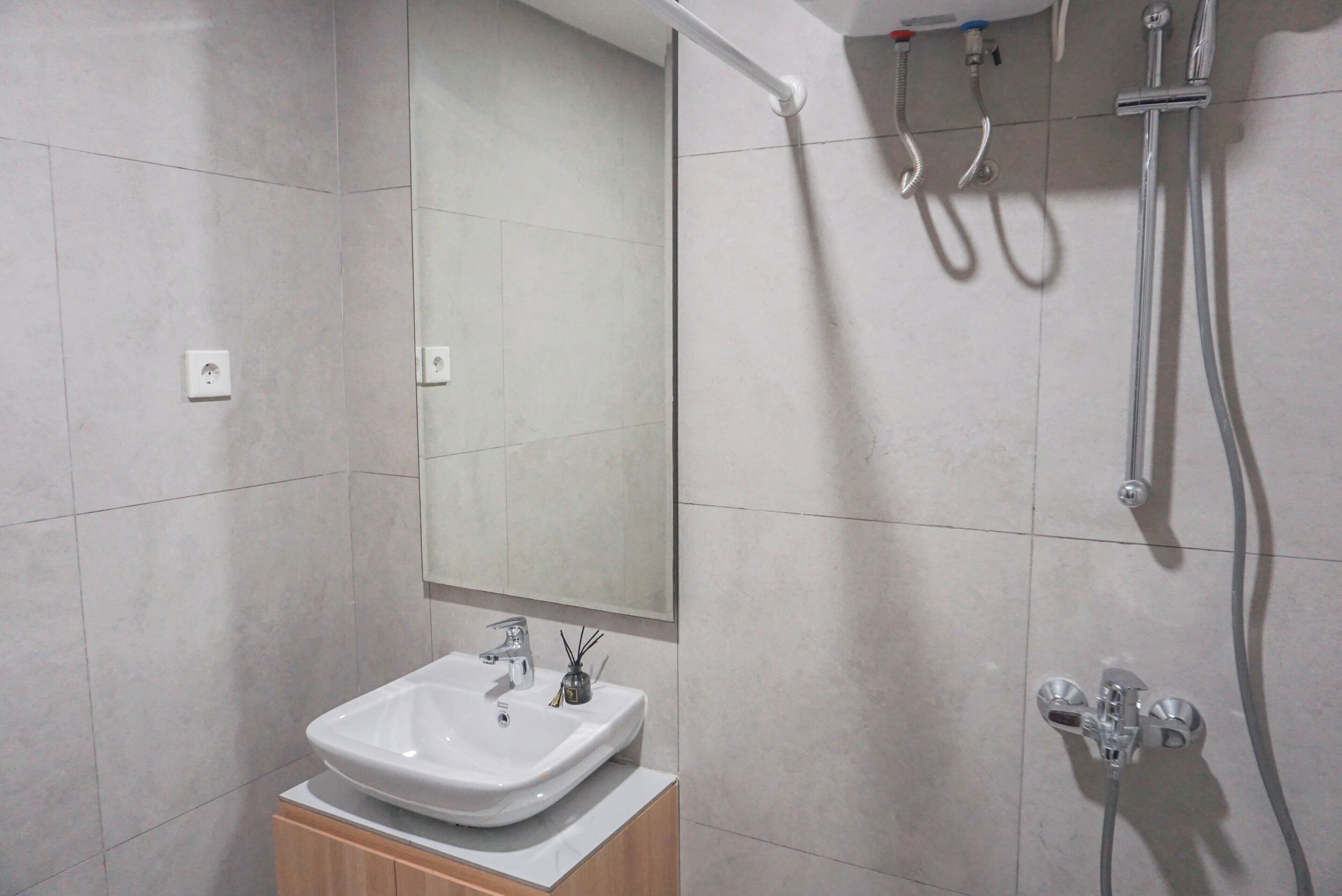 Une salle de bain moderne avec un lavabo blanc, un miroir et une douche.