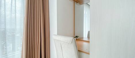 A room with a large mirror, a wooden desk, and a chair.