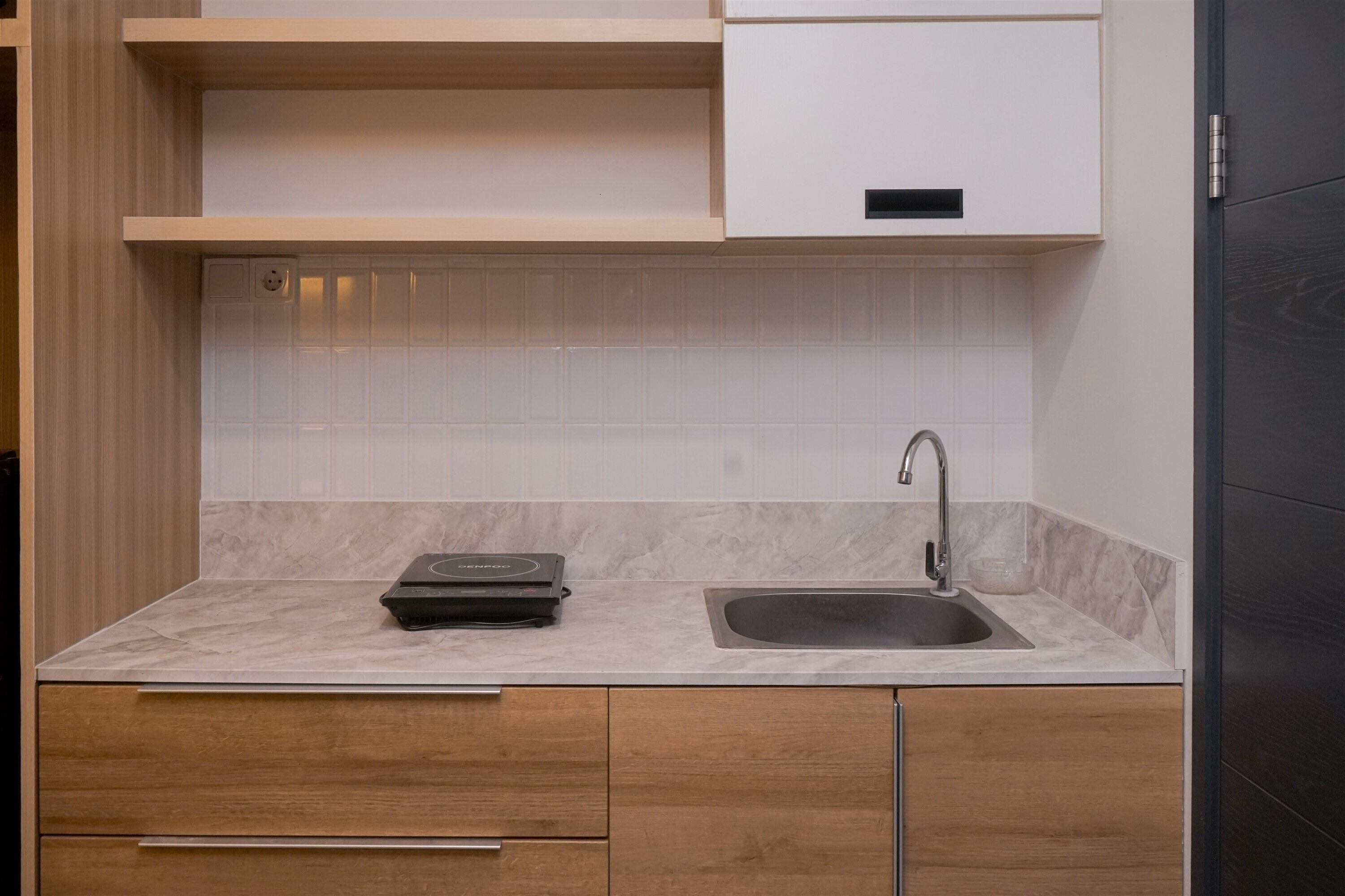 Una cocina moderna con encimera de mármol, pileta integrada y muebles de madera.