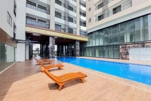 Relax by the rectangular pool surrounded by a tiled deck and lounge chairs.