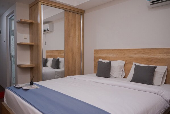 Comfortable retreat with a large bed, wooden headboard, and ample storage.