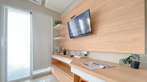 A modern kitchen with a wooden countertop, a built-in TV, and a sliding glass door. - Spacious And Comfy Studio Apartment Royal Sentul Park (Bogor)