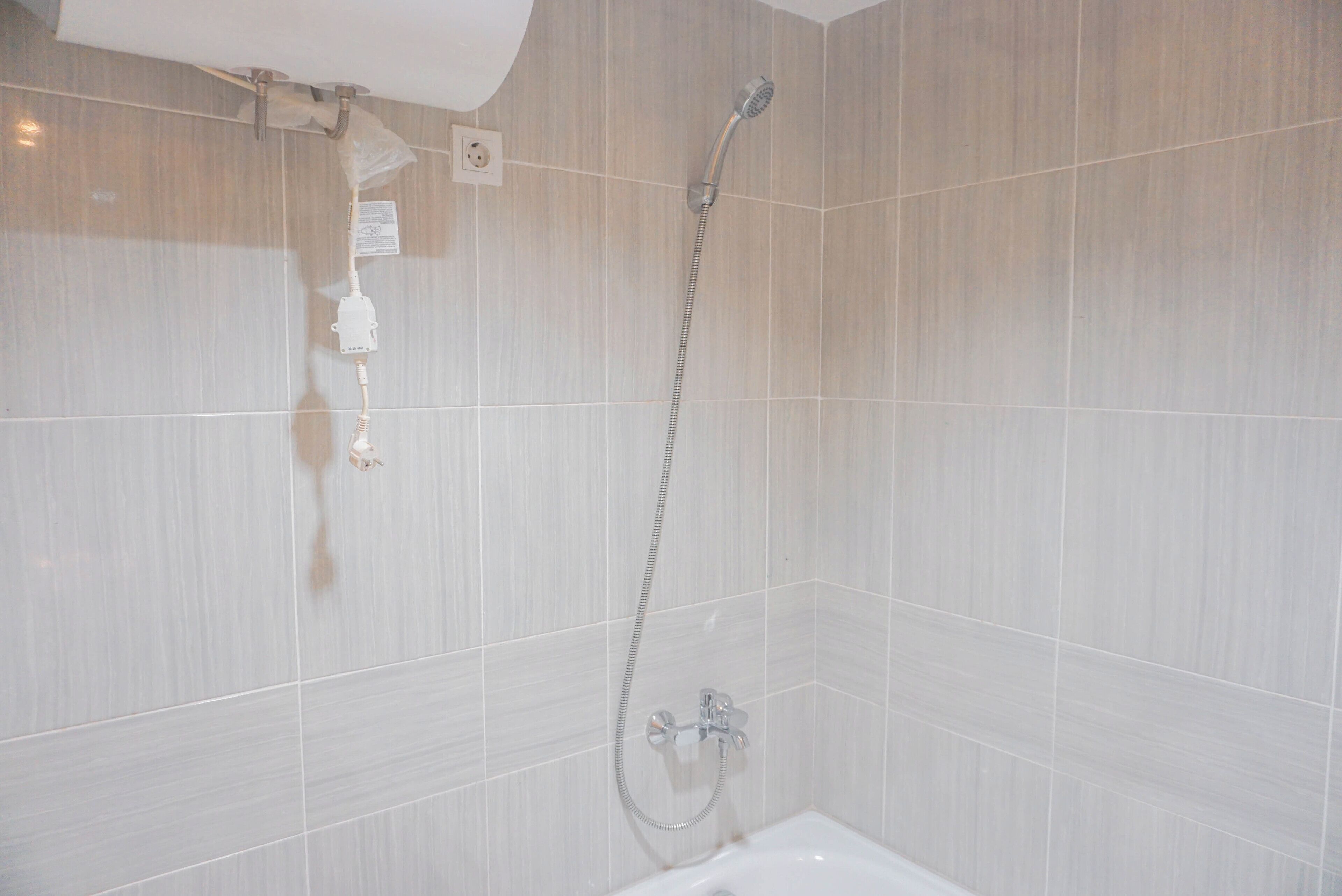 Une salle de bain avec une douche, une baignoire et un porte-serviettes.