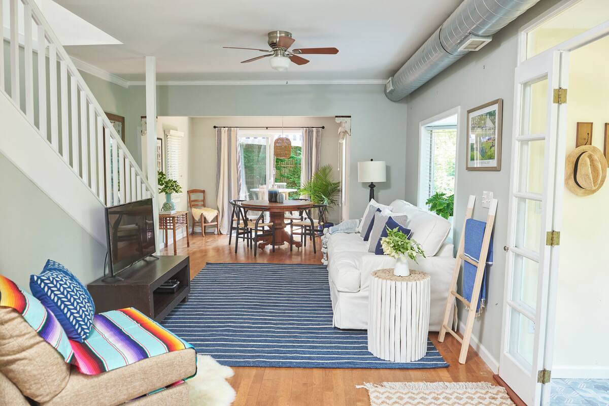 A living room with a sofa, TV, and a dining area with a table and chairs.