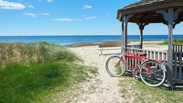 A beach scene with a wooden gazebo, a red bicycle, and a bench. - Bellport Inn (Bellport)