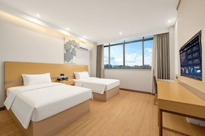A hotel room with two beds, a desk, a TV, and a window with a city view. - GreenTree (Jiangyin High-Speed Railway Station Meiyuan Avenue) (Jiangyin)
