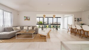 A modern living room with a sofa, coffee table, and dining area with chairs. - Villa Coastal Bliss with private pool & sea view at Jan Thiel (Jan Thiel)