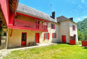 Un immeuble de deux étages avec un balcon rouge et des portes rouges.