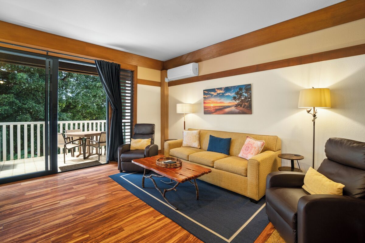 A living room with a sofa, a coffee table, a lamp, and a painting on the wall.