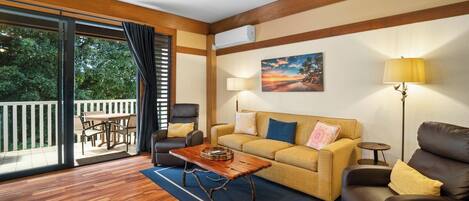 A living room with a sofa, a coffee table, a lamp, and a painting on the wall.