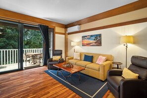 A living room with a sofa, a coffee table, a lamp, and a painting on the wall.