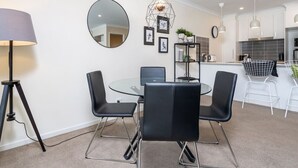 A modern kitchen with white cabinets, a round mirror, and a hanging light fixture. - Cosy 2BR Close to Light Rail (Harrison)