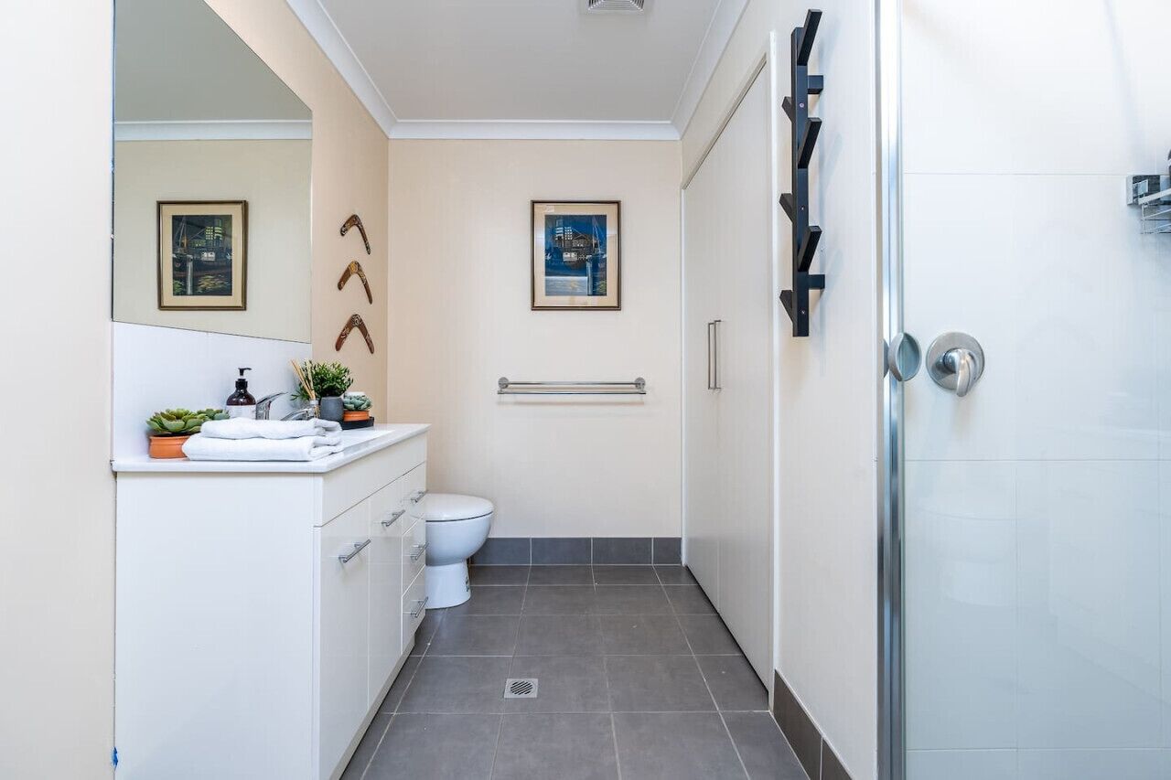 Un baño moderno con inodoro, lavamanos y cabina de ducha.