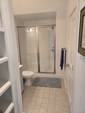 A bathroom with a glass-enclosed shower, a toilet, and a sink. - Charming carriage house in marvelous Watercolor. (Santa Rosa Beach)