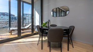 Un comedor moderno con separador de vidrio, una mesa redonda y cuatro sillas.