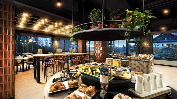 Um buffet de café da manhã com diversos alimentos, um espaço para café e vista para o exterior.