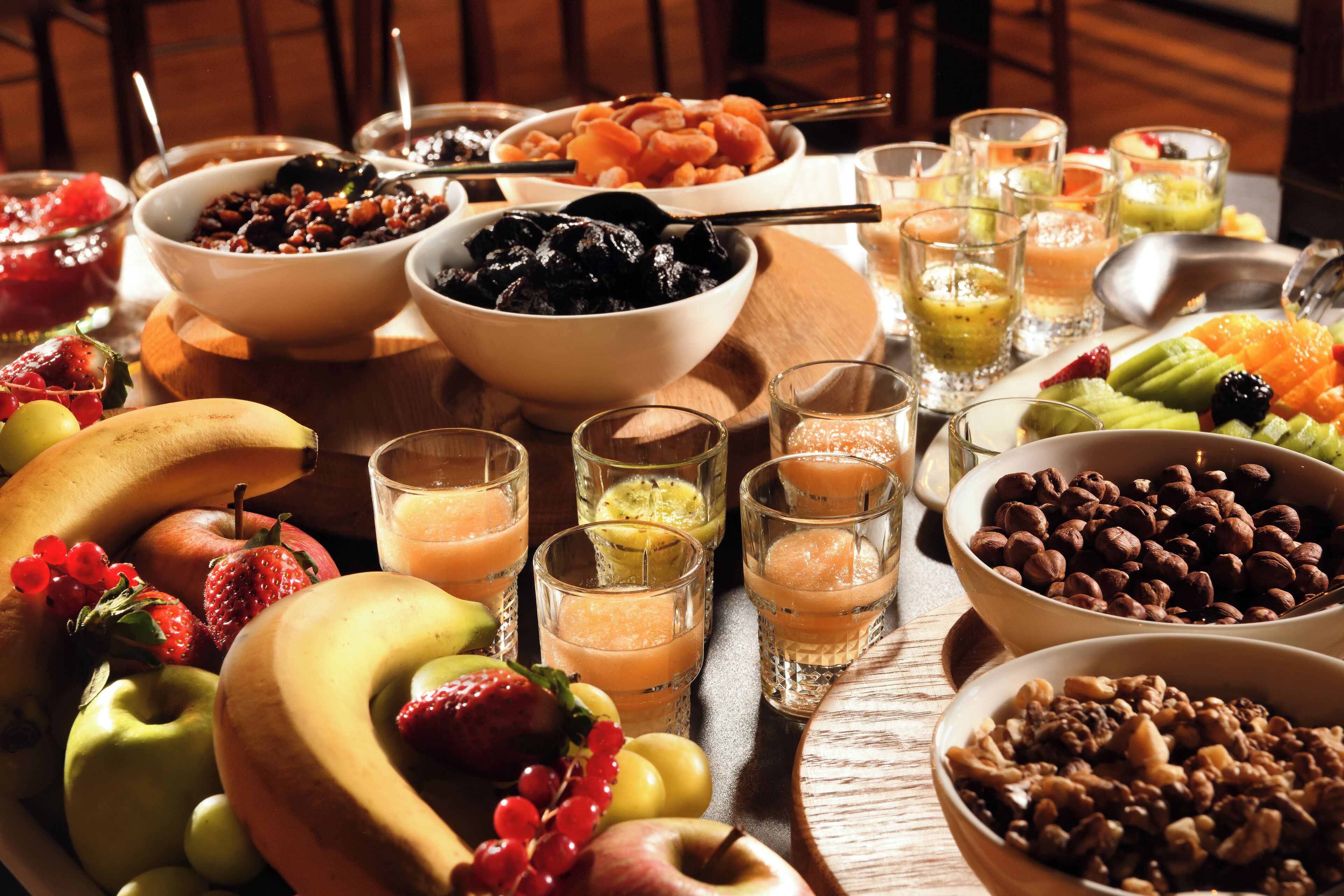 A table with various fruits, nuts, and beverages.
