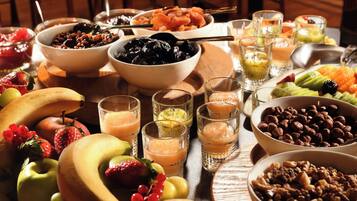 A table with various fruits, nuts, and beverages.
