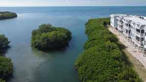 A coastal hotel with a view of the sea, a small island, and lush greenery.
